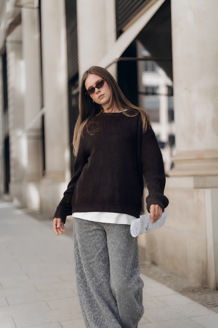 Graue Jeans YOSIE mit weitem Bein und Leo-Print an Model gestylt mit Pullover COSIMA in Dunkelbraun und Oversized T-Shirt ALL TIME BASIC in Weiß.